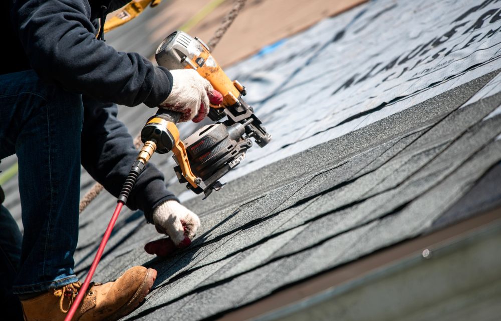 Roof-replacement A man using a nail gun and replacing a roof.